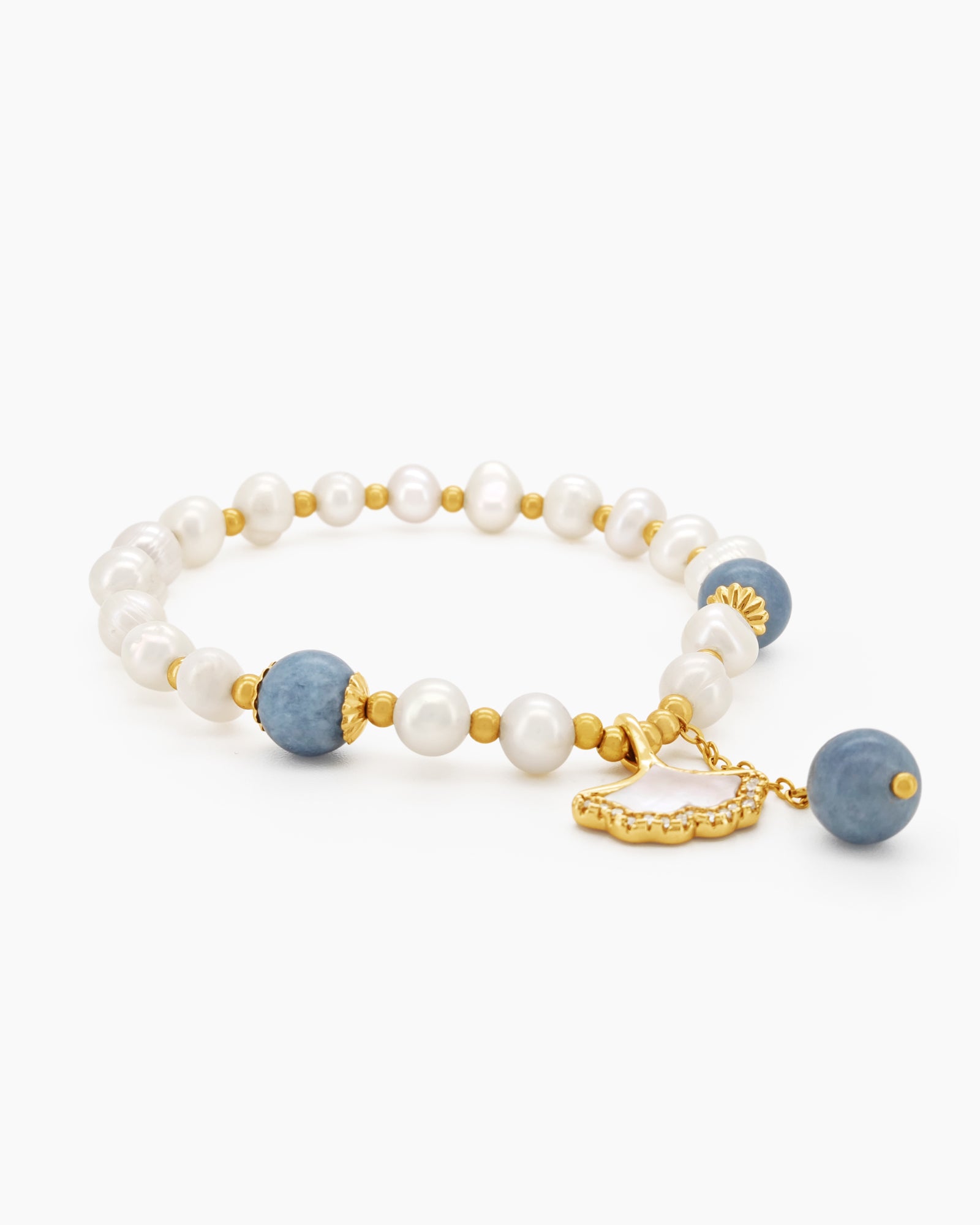 A hand-strung bracelet with creamy freshwater pearls, aquamarine crystals, and a mother-of-pearl charm
