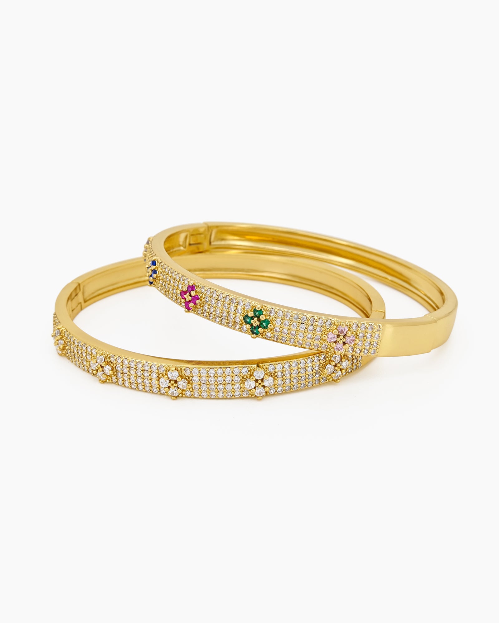 A gold bangle with a sleek silhouette, adorned with pavé-set crystals and playful multicolored floral motifs