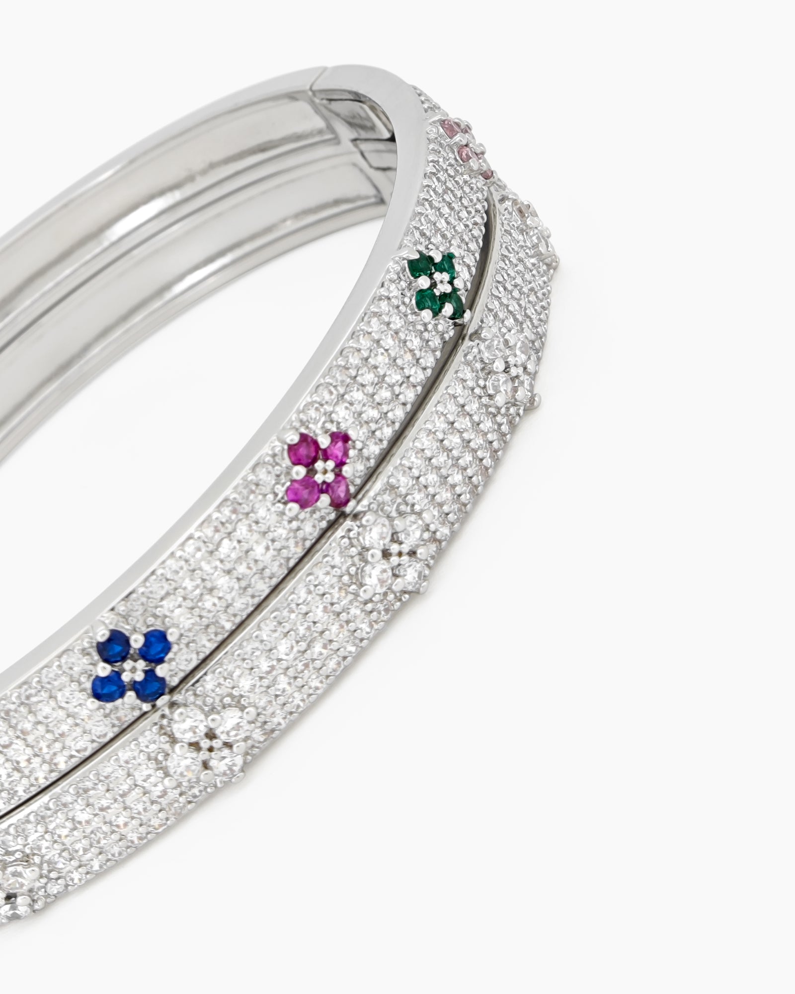 A silver bangle with a sleek silhouette, adorned with pavé-set crystals and brilliant clear zircons