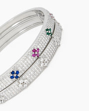 A silver bangle with a sleek silhouette, adorned with pavé-set crystals and brilliant clear zircons