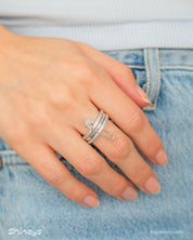 A silver stacked band ring with a crystal-studded safety pin detail for a stylish, daring twist
