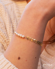 A bracelet of textured laurel leaves and luminous freshwater pearls for a look of classical beauty