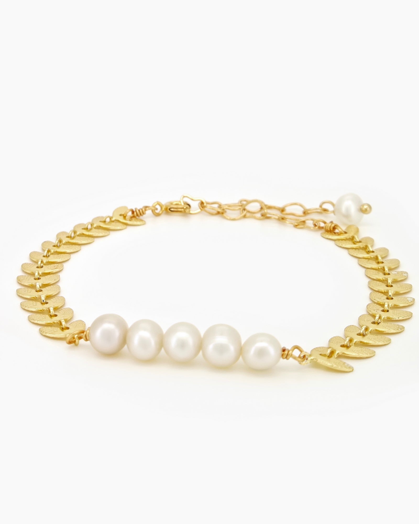 A bracelet of textured laurel leaves and luminous freshwater pearls for a look of classical beauty