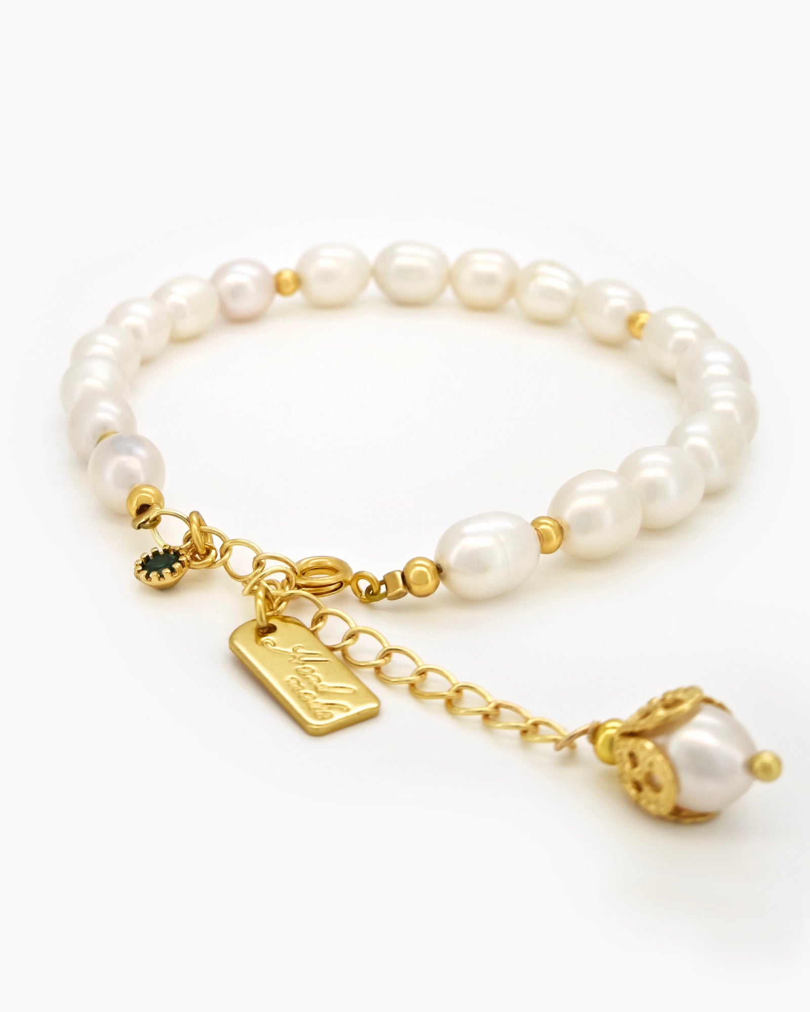 A bracelet of lustrous freshwater pearls and polished gold-toned beads with a trio of statement charms