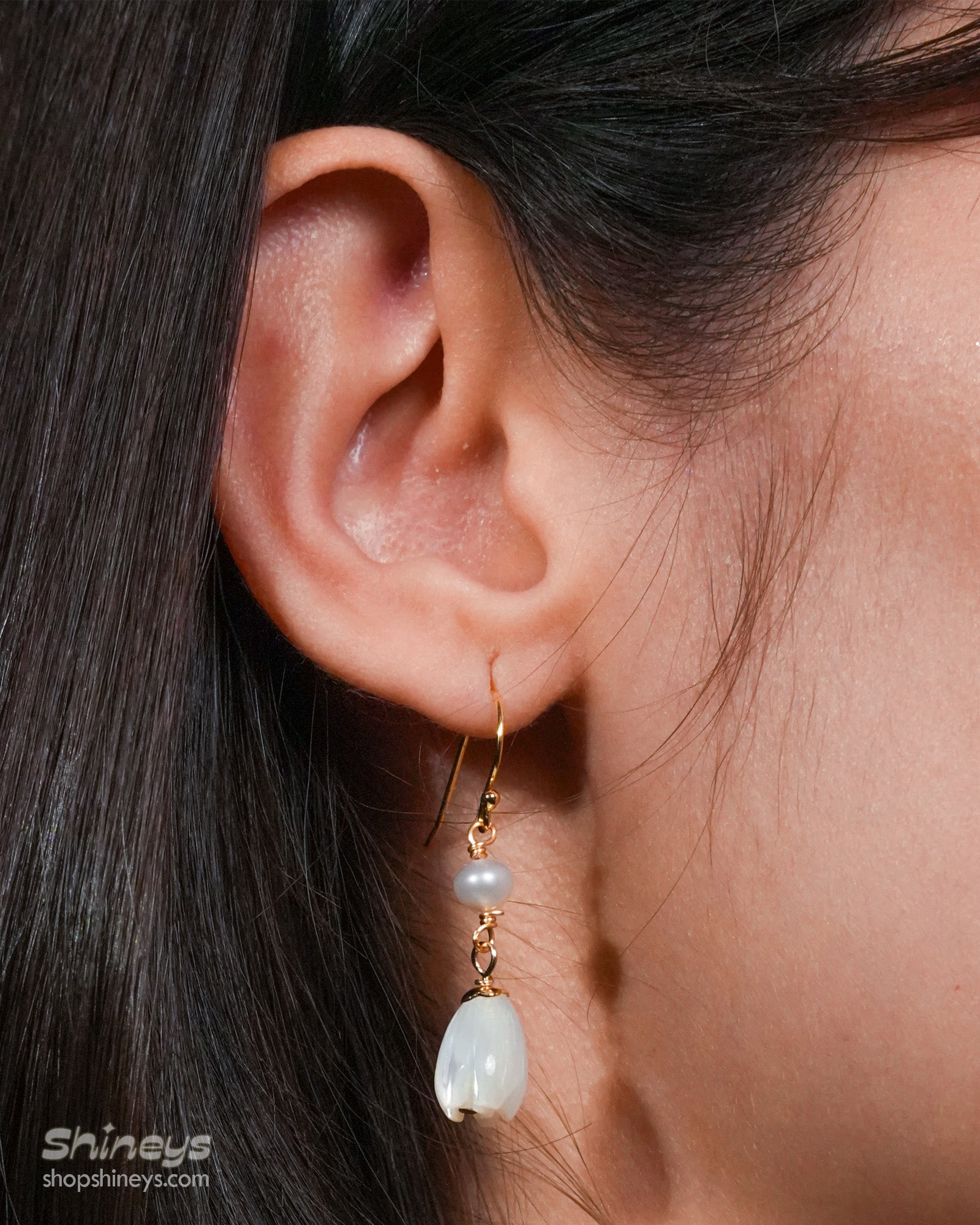 Earrings with mother-of-pearl floral drops that sway gently beneath a dainty freshwater pearl