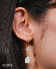 Earrings with mother-of-pearl floral drops that sway gently beneath a dainty freshwater pearl
