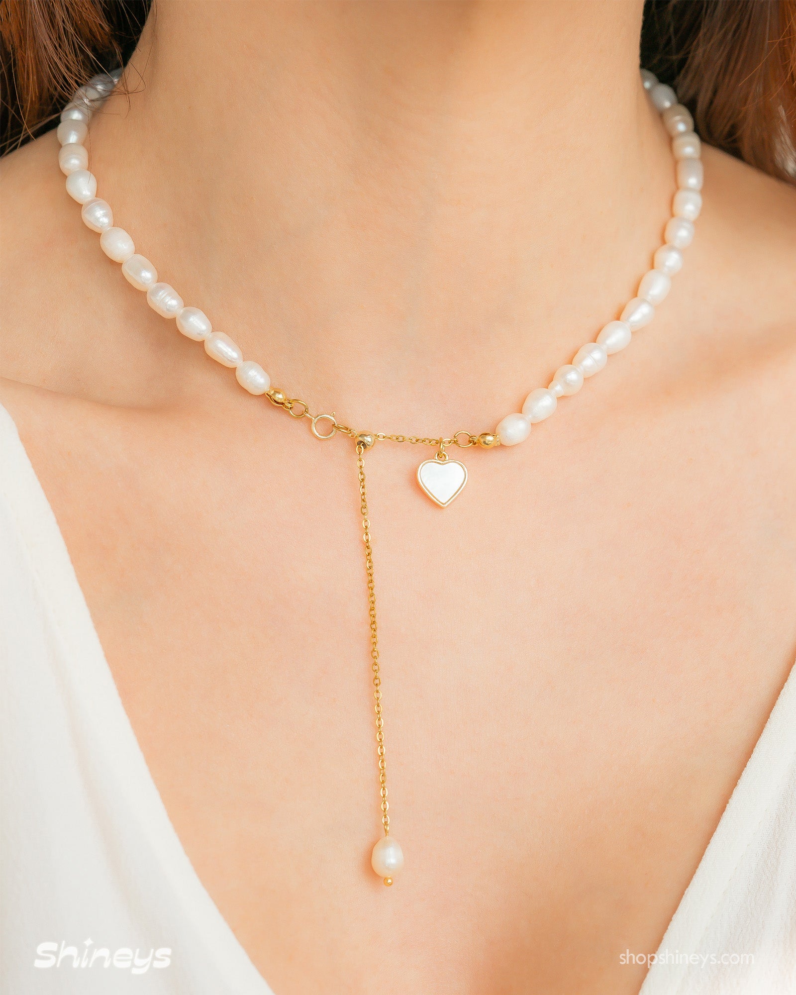 A necklace with a graceful strand of freshwater pearls and a mother-of-pearl heart charm