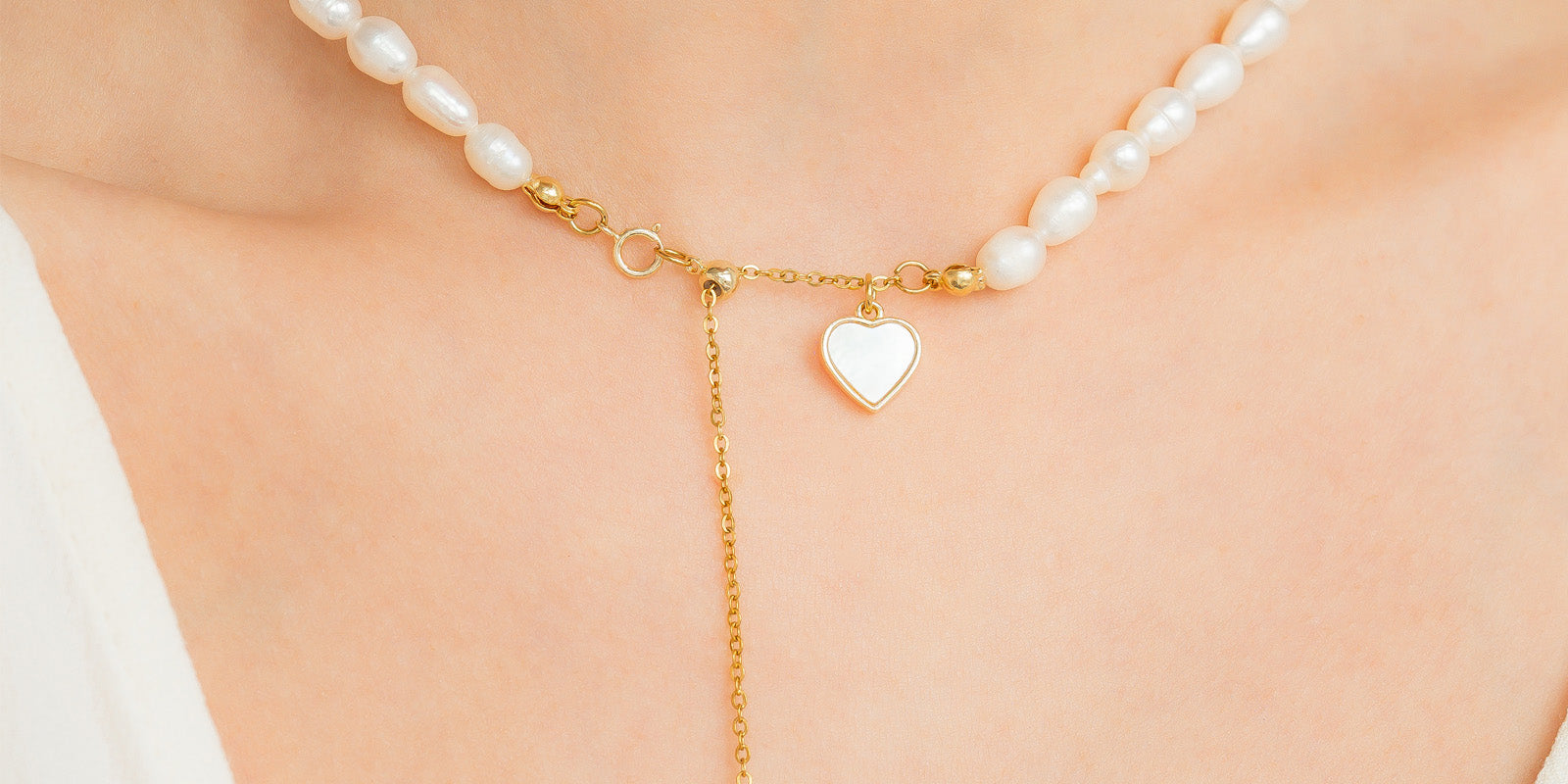 A necklace with a graceful strand of freshwater pearls and a mother-of-pearl heart charm