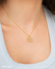 A gold necklace with a clover-inspired pendant of four pavé-outlined hearts that opens up
