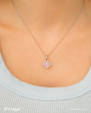 A pink necklace with a clover pendant outlined in pavé zircons and a faceted four-petal center stone