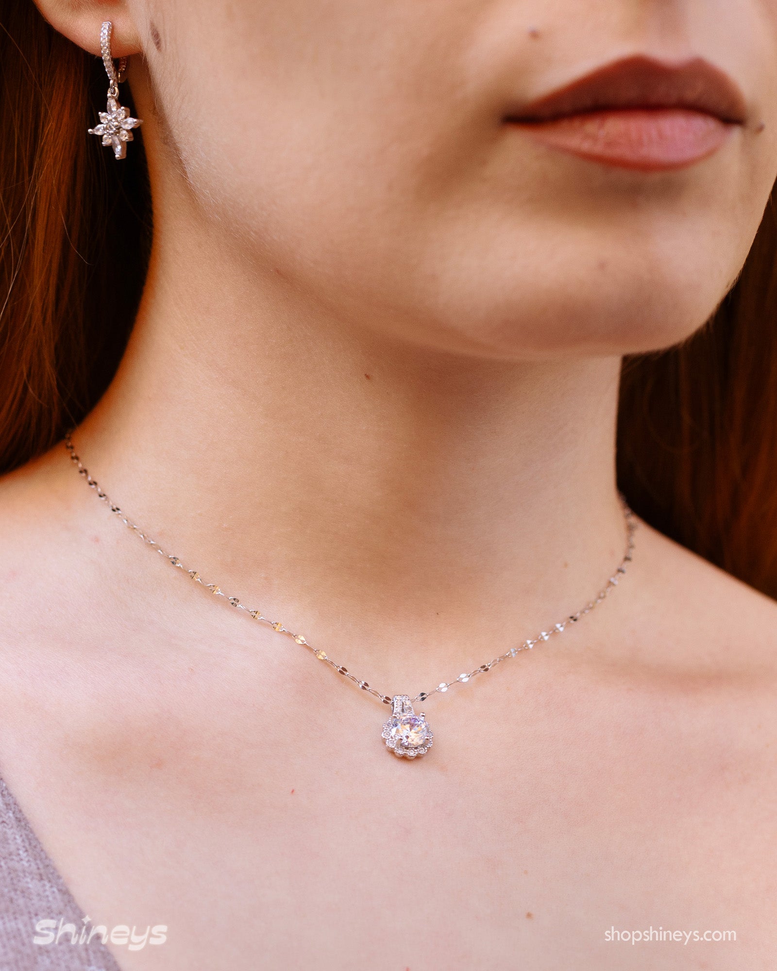 A necklace with a brilliant-cut white zircon pendant, framed by a sparkling halo of micro-set stones