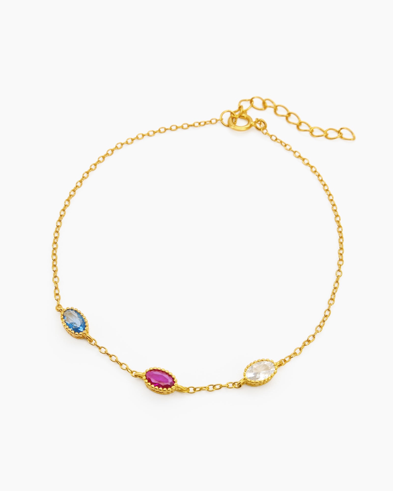 An elegant bracelet with three bezel-set oval zircons, each in a unique hue, on a fine cable chain