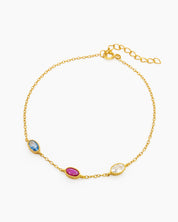 An elegant bracelet with three bezel-set oval zircons, each in a unique hue, on a fine cable chain