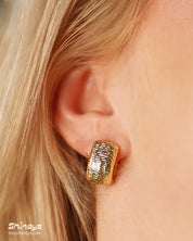 Chunky gold hoops with a sculpted, densely textured surface that creates depth and movement