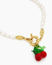 A necklace of timeless freshwater pearls with a glossy cherry pendant for a playful pop of color