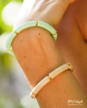 A playful ocean bangle with smooth, curved acrylic segments and delicate golden connectors