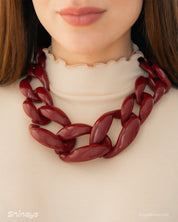 A wine-red necklace with a dynamic progression of oversized, high-shine links for a sculptural look