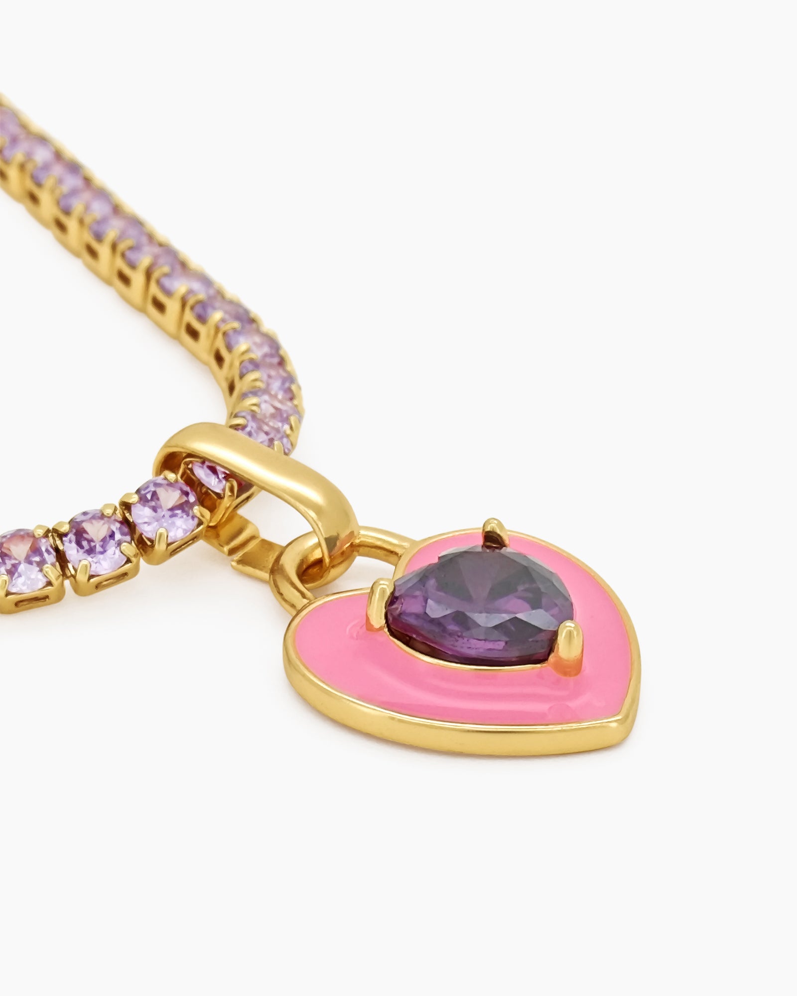 A light-pink tennis necklace with a full strand of zircon stones and an enamel heart charm with a center stone