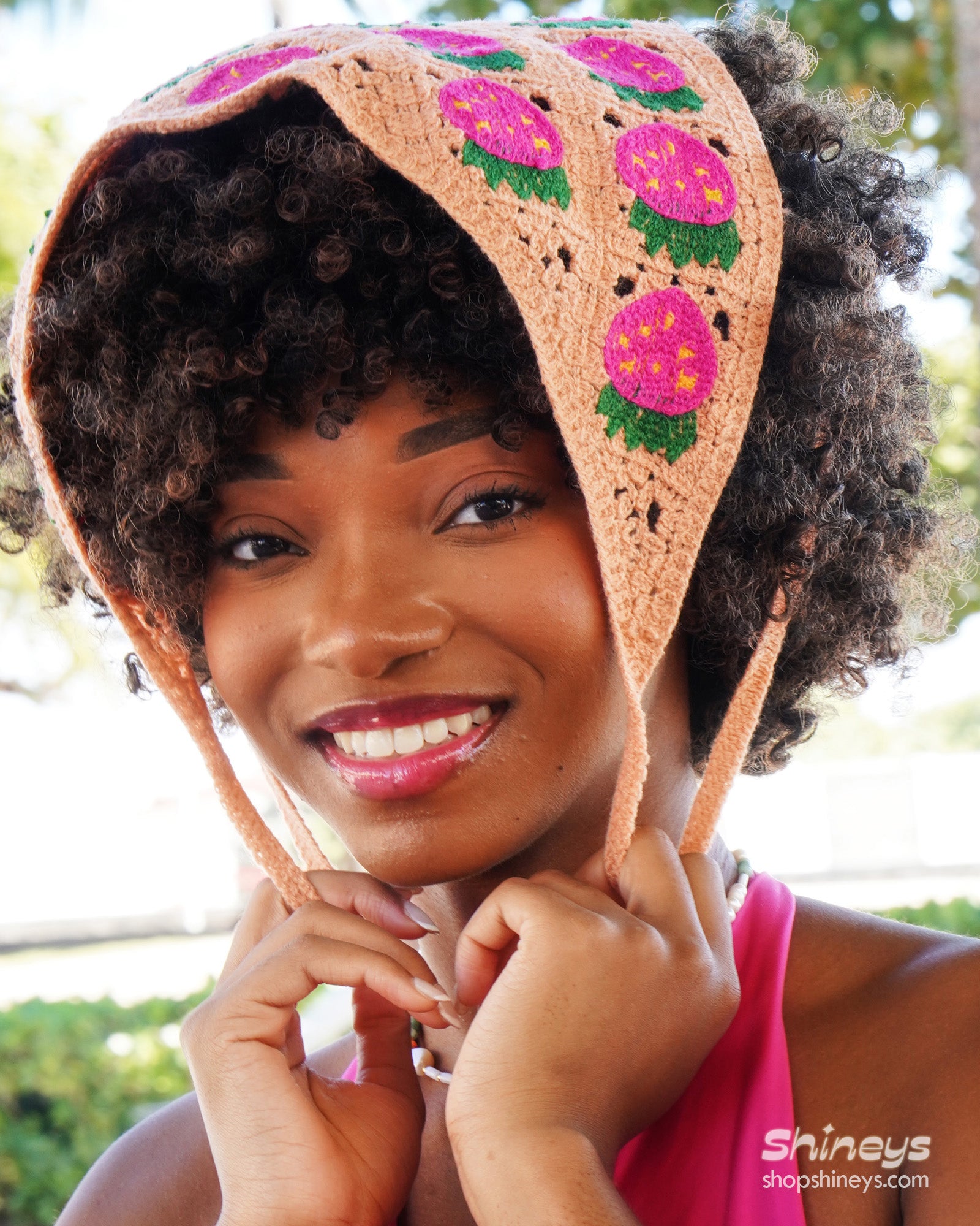 A hand-crocheted headscarf in light-green with adorable strawberry motifs for a sweet, whimsical look