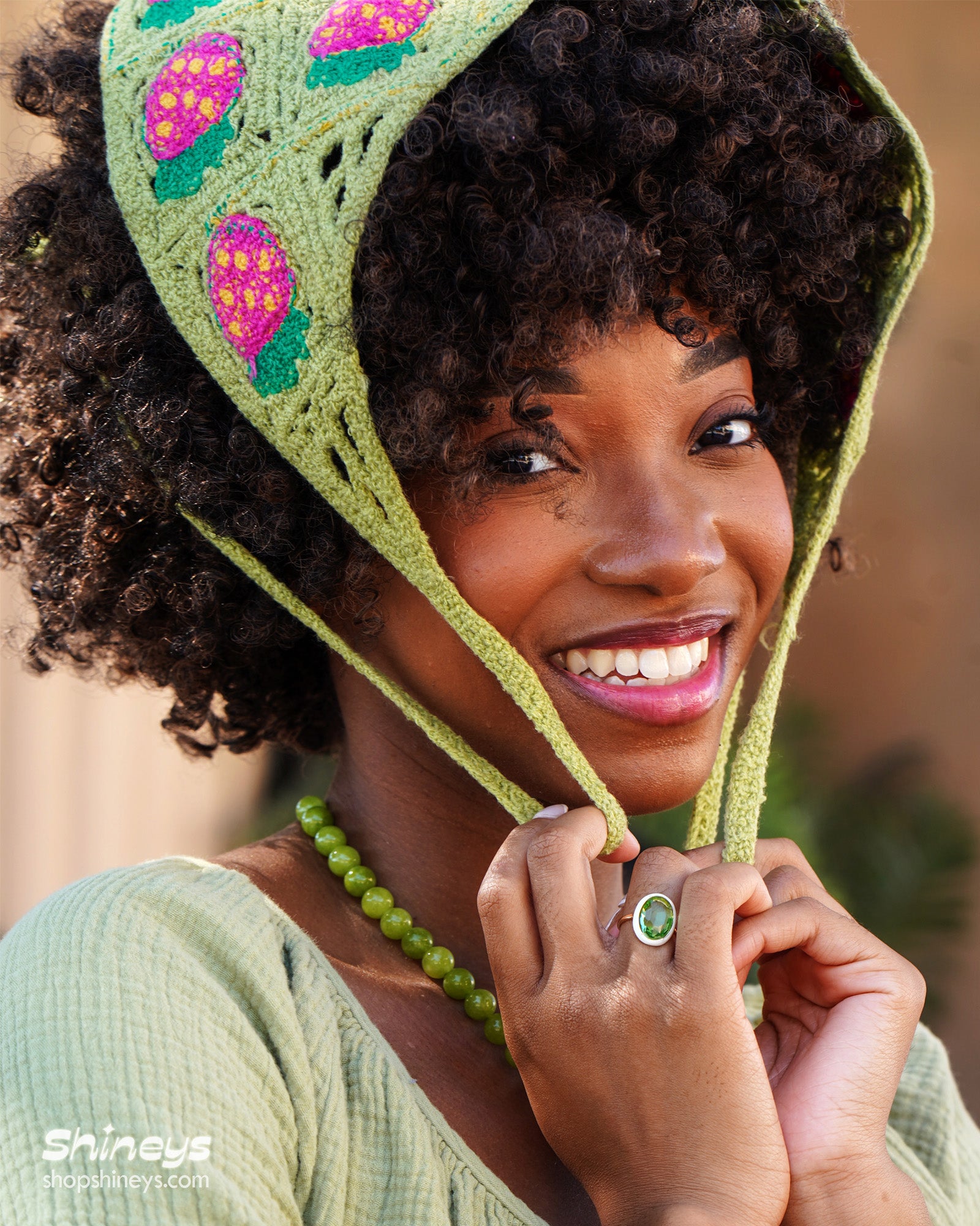 A hand-crocheted headscarf in white with adorable strawberry motifs for a sweet, whimsical look
