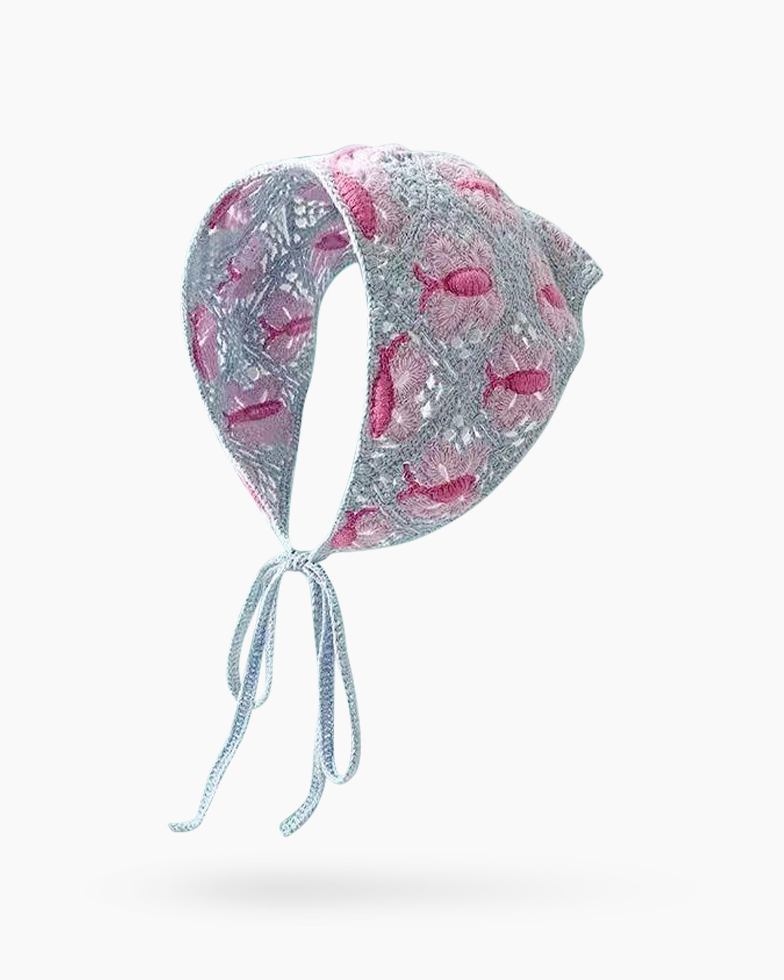 A lace-knit triangle scarf in dusty blue with intricately embroidered pink butterfly motifs