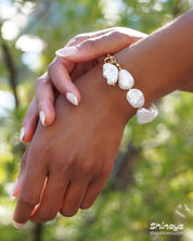 A bracelet of shimmering baroque pearls nestled between dainty gold beads, with a bold T-bar toggle clasp