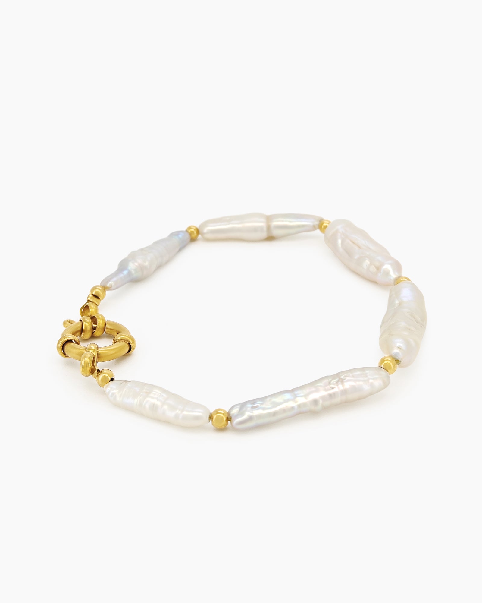 A bracelet of elongated baroque pearls with soft, iridescent sheen, accented by delicate gold-toned beads