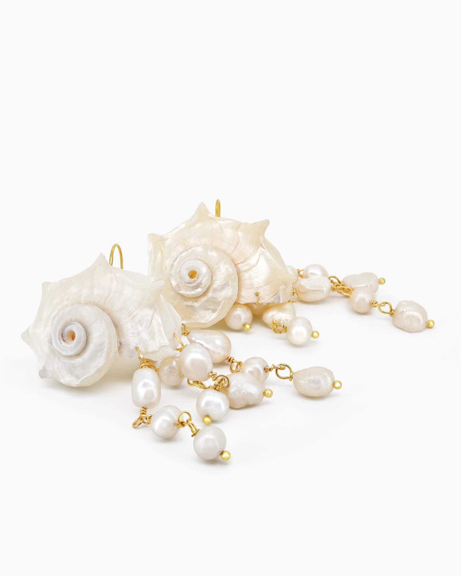 Statement earrings with sculpted conch shells and cascading strands of luminous freshwater pearls