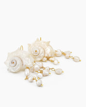 Statement earrings with sculpted conch shells and cascading strands of luminous freshwater pearls
