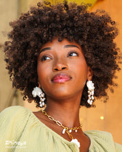 Statement earrings with sculpted conch shells and cascading strands of luminous freshwater pearls