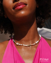 A beaded necklace with freshwater pearls, coral-hued cylinders, and sea-green faceted agate beads