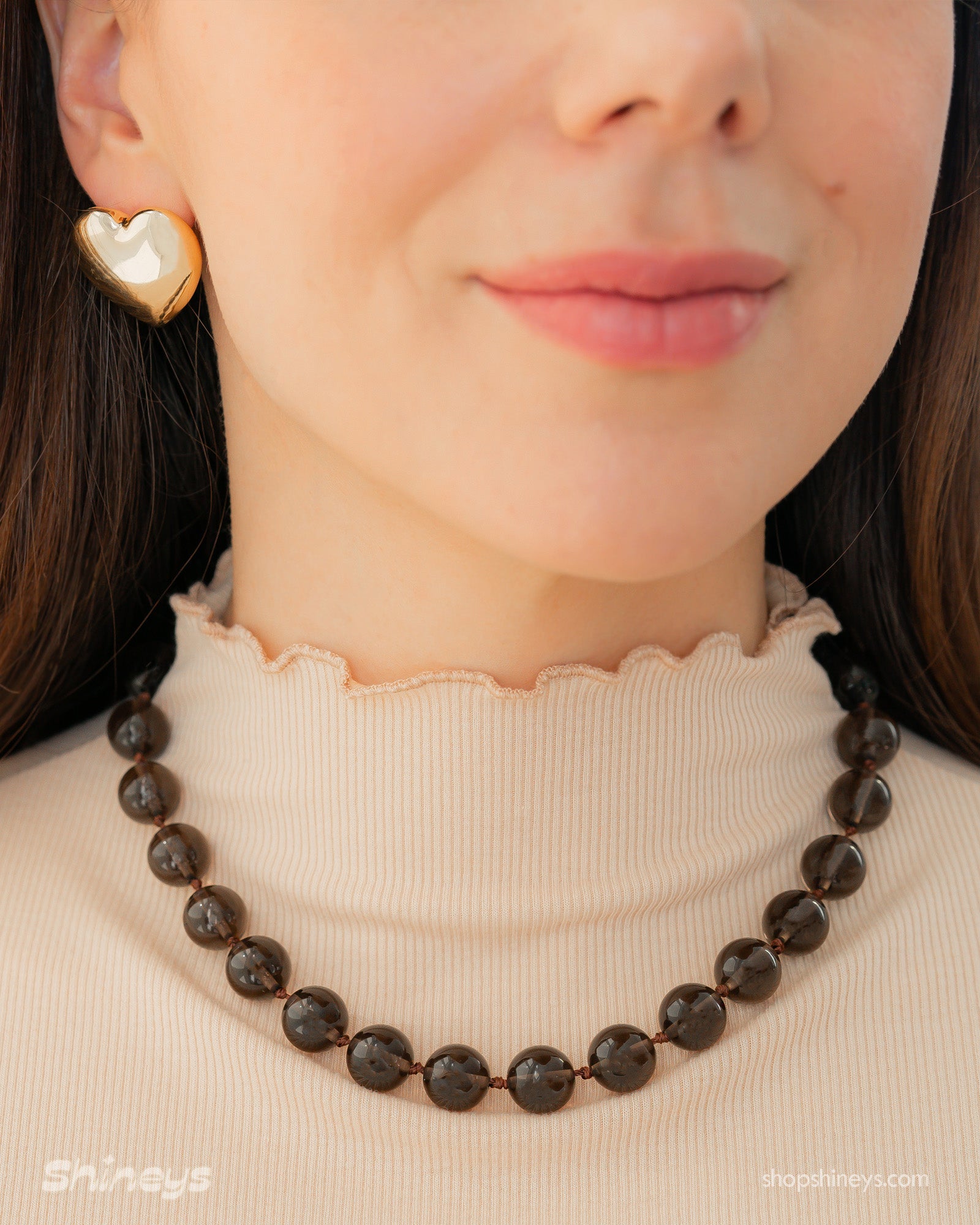 A &#39;90s safari-style necklace with smooth, polished brown stones for a grounded, earthy charm