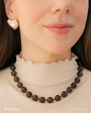 A '90s safari-style necklace with smooth, polished brown stones for a grounded, earthy charm