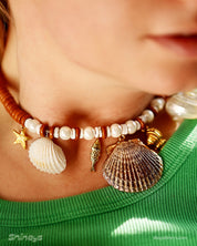 A necklace of natural wood-toned discs, freshwater pearls, and a cascade of sea-inspired charms