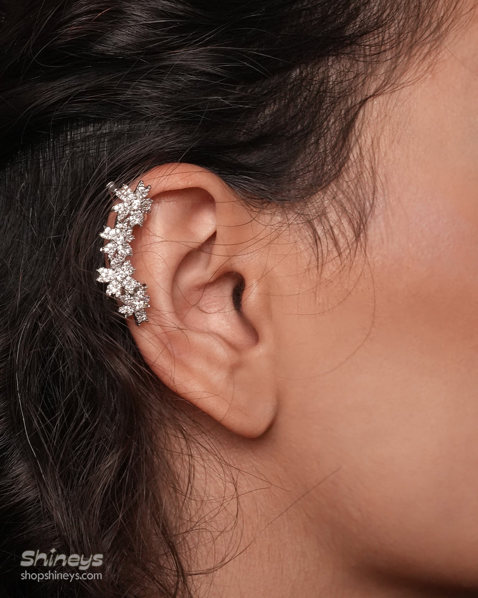 Ear cuffs with shimmering zircon blossoms, designed to hug the curve of the ear for a sparkling look